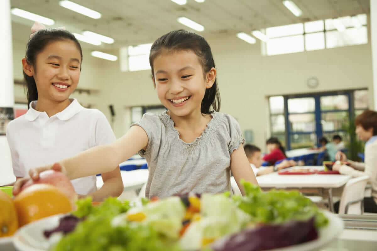 Two children selecting lunch items.