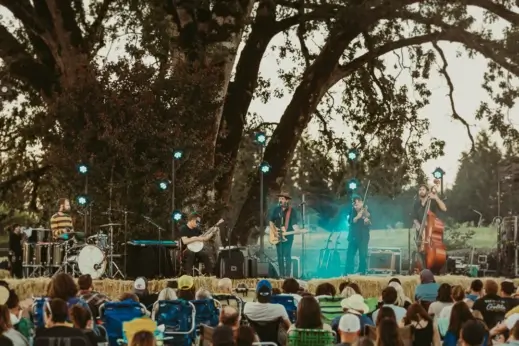 People sit on lawn chairs listening to live music.